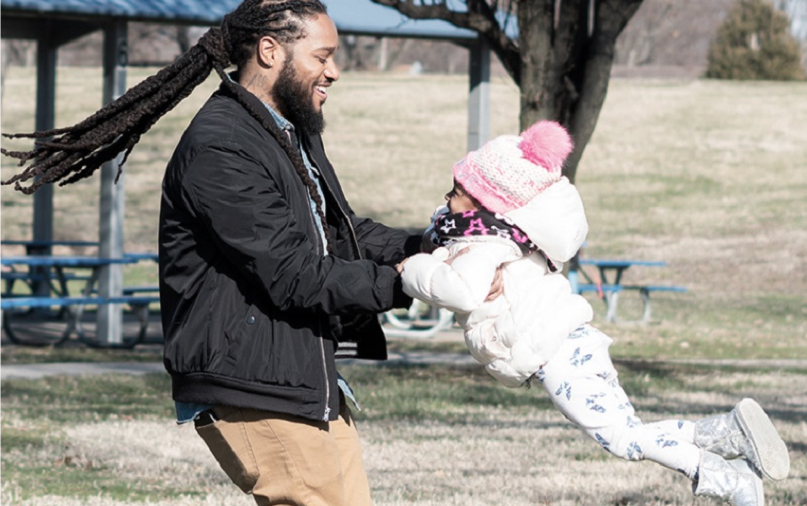 Kori lifting up Corlena at a park